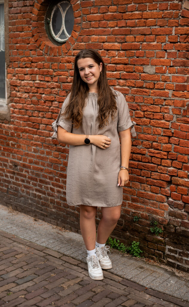 Taupe jurk met strikdetail op de mouw